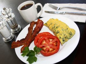 Image of a breakfast of lean bacon, tomato slices, and a zip-lock omelet.